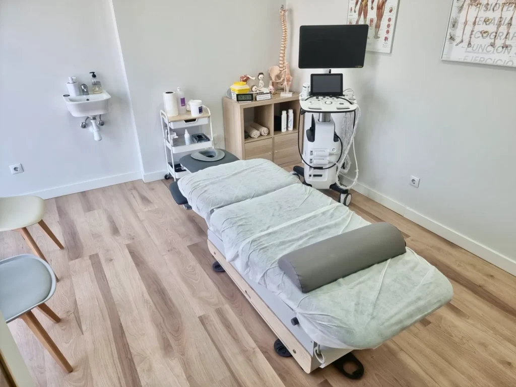 Sala de tratamiento equipada con camilla y ecógrafo